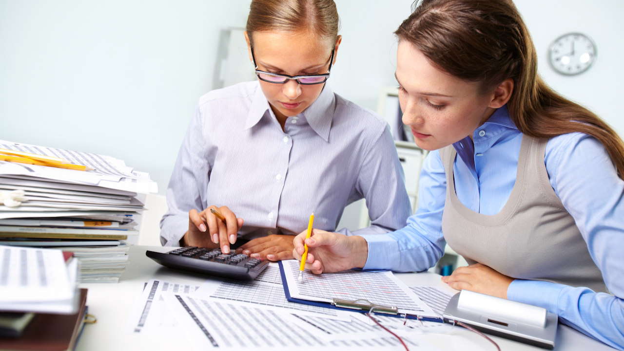 Concentrated business women reviewing accounting report