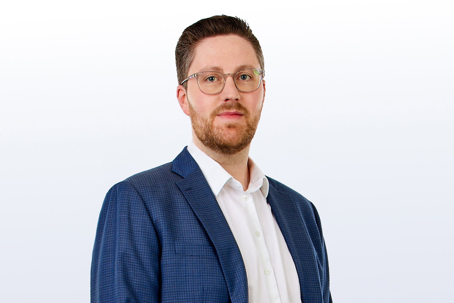 Dirk Klümper, der Hauptansprechpartner für den Standort von TriFinance in Köln, steht in weißem Hemd mit dunkelblauem Sakko vor einem weißen Hintergrund und lächelt selbstbewusst in die Kamera.